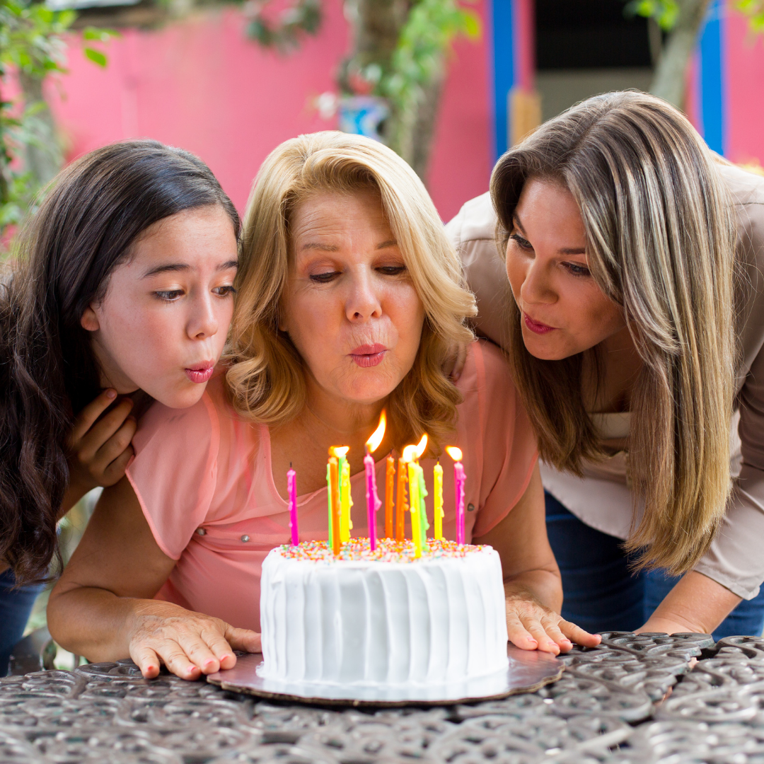 woman over 40 blowing out candles